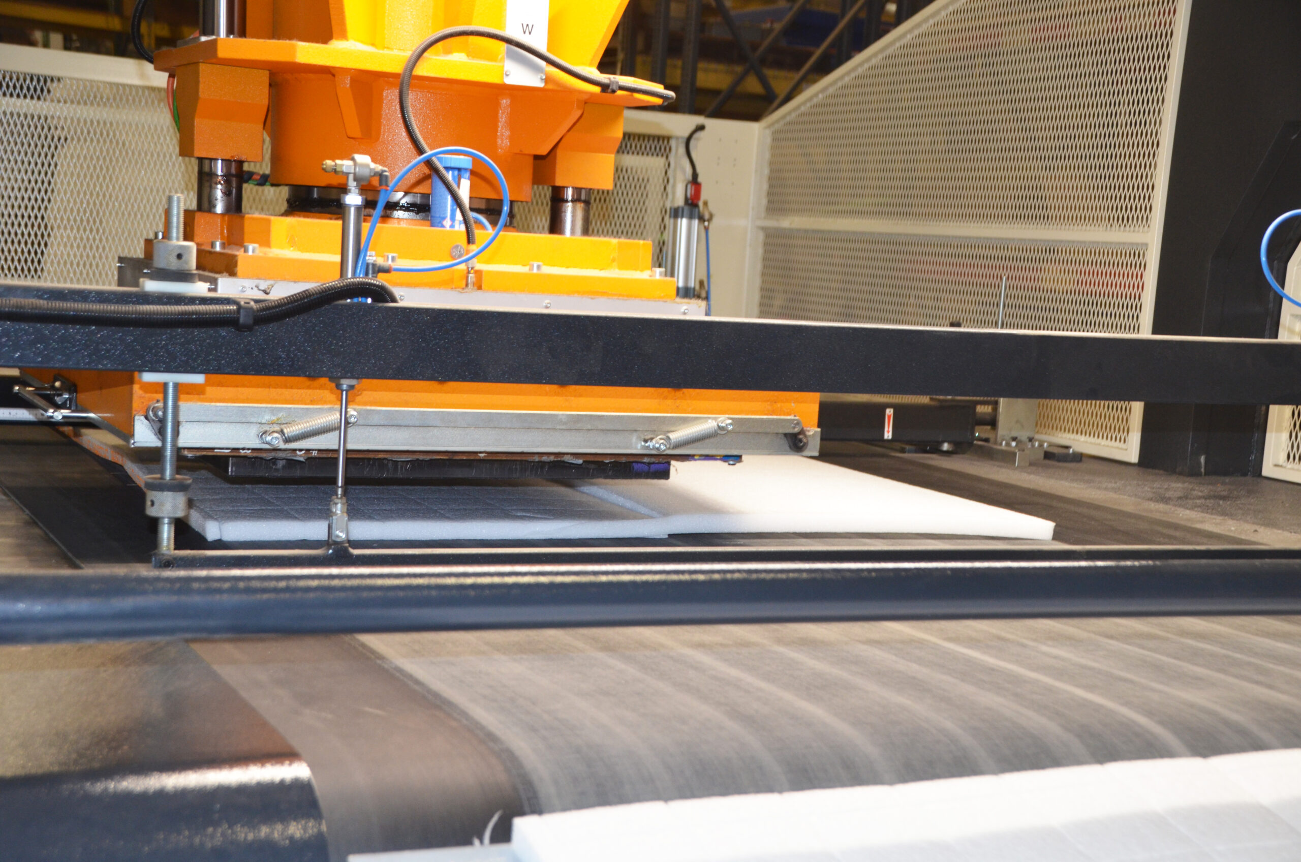 Machine cutting foam sheets in a production facility.